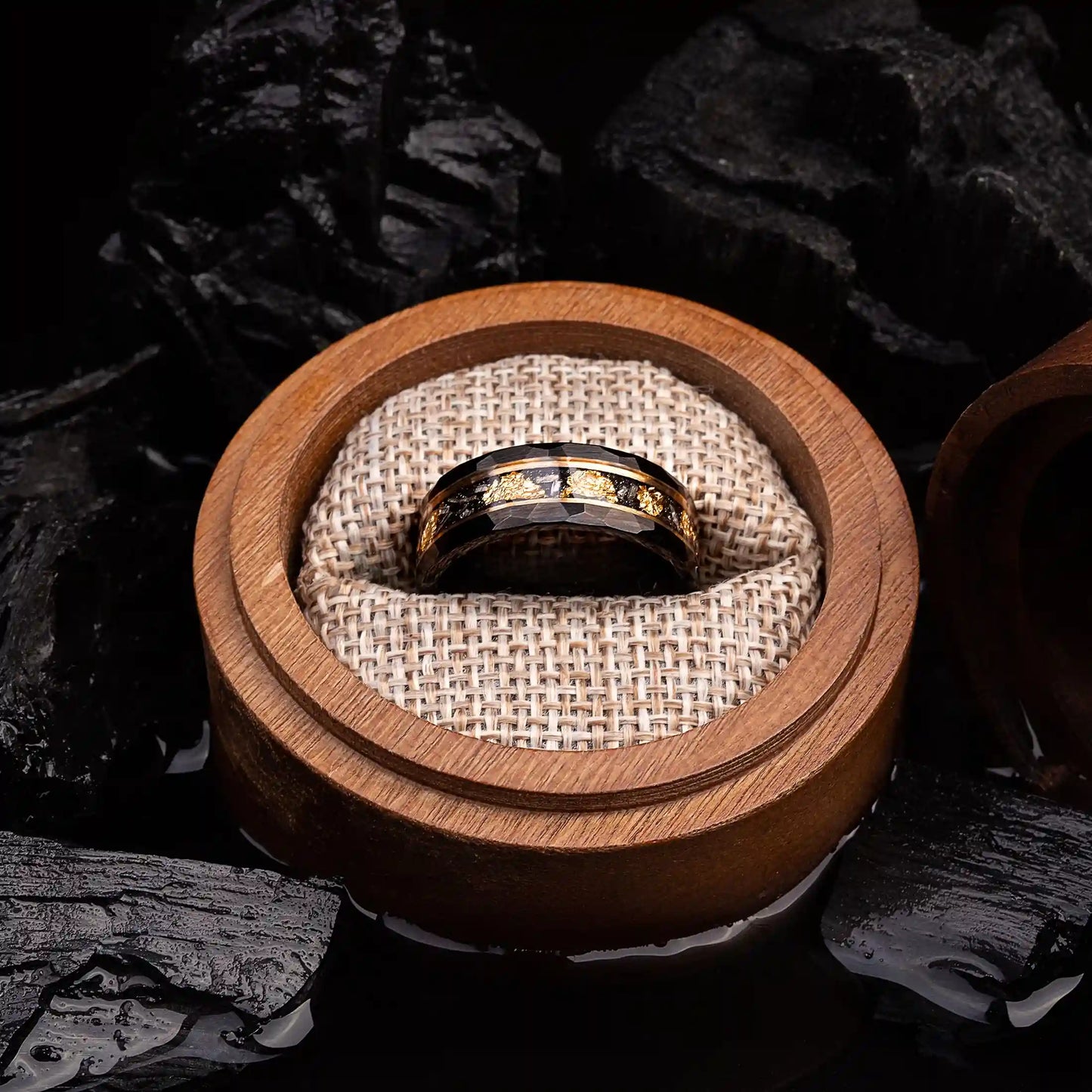 Black hammered tungsten ring with gold and meteorite. The ring is placed inside a round wooden box