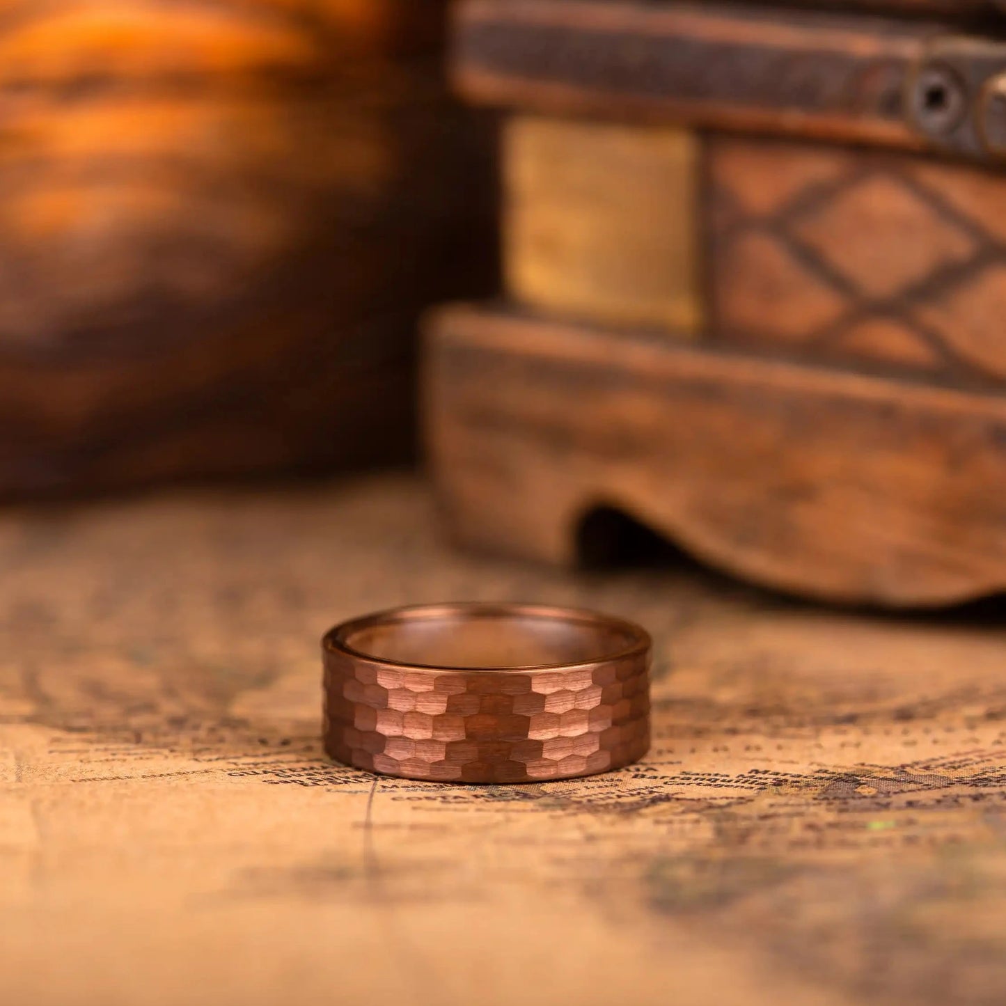 Red hammered tungsten ring with wenge wood inlay. The ring is laying on a map